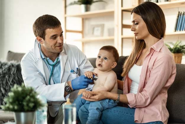 Niño teniendo un examen médico por un pediatra masculino mientras estaba con su madre el foco está en el médico