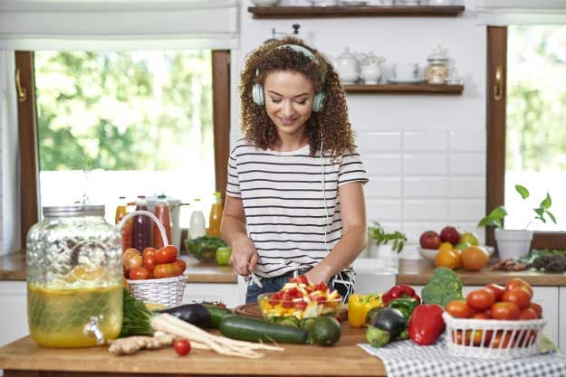 Mujer cocinando y escuchando música