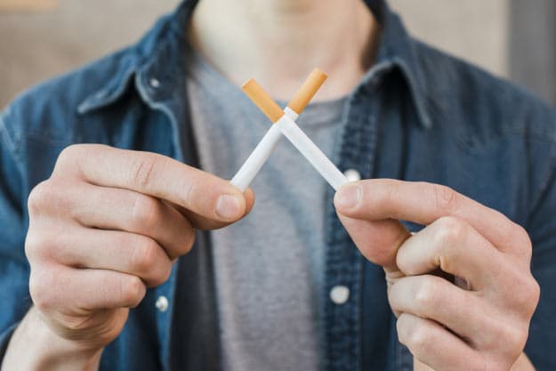 Mano del hombre sosteniendo cigarrillos cruzados Foto gratis Mano del hombre sosteniendo cigarrillos cruzados Foto gratis